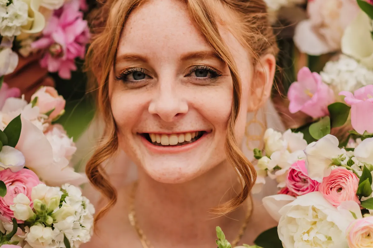 Woman smiling surrounded by flowers